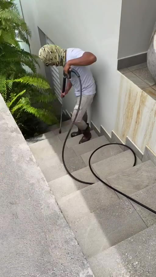 Personne réalisant un nettoyage haute pression sur un escalier extérieur